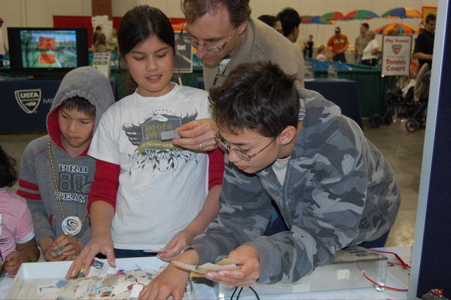 Youth finding and selecting stamps to keep from the on-paper mixture.